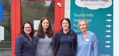 Dort ist das Team des Kurzentrums zu sehen. Es sind vier Frauen die vor der roten Eingangstür des Kurzentrums stehen.